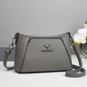 Detail view of the gray lychee pattern leather texture and metal strap hardware on the bag