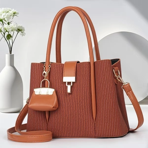Detailed macro view of the striped pleated texture and golden hardware of the brown tote bag