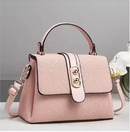 Detailed view of pink crossbody bag with woven texture and gold twist-lock buckle