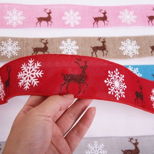 Detailaufnahme von bunten Weihnachtsbändern mit Schneeflocken und Rentier-Motiven
