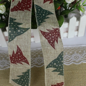 Close-up of faux linen Christmas ribbon with printed red and green holiday tree patterns