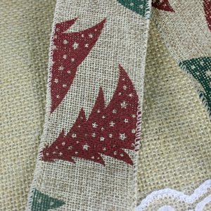 Detail of jute Christmas ribbon with red green tree prints and white lace edge decoration