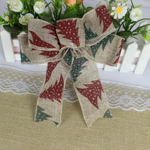 Detail of burlap Christmas bow with red and green tree print for festive holiday decoration