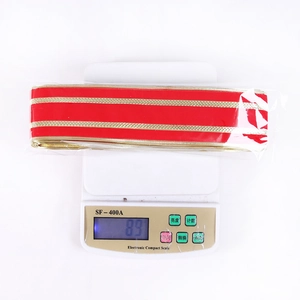Close-up of red velvet Christmas ribbon with gold edges on an electronic scale
