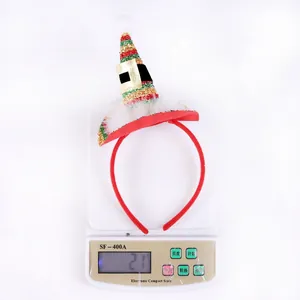 Elf hat headband with red green gold glitter and plush pompom on a digital scale