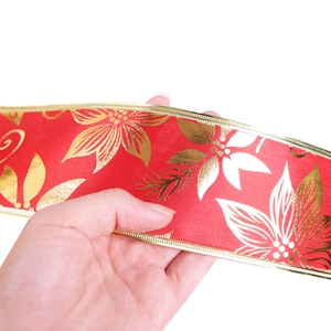 Close-up of 10m red Christmas ribbon with gold floral print and metallic stitched edges
