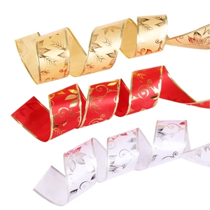 Close-up of three decorative Christmas ribbons in gold, red and white with floral patterns