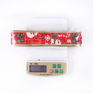Detail of red Christmas ribbon weighing 78g on a digital scale for gift wrapping