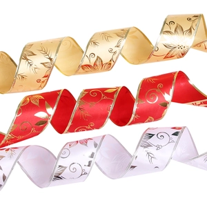Detail of Christmas ribbon rolls in red, gold, and white with floral metallic prints