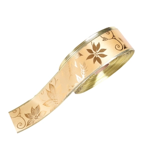 Detail of champagne gold satin ribbon with metallic flower patterns for gift wrapping