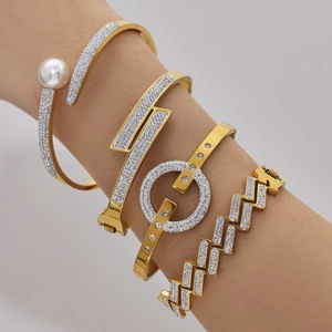 Parure de bracelets dorés 18K avec zircons 5A scintillants et perle sur poignet féminin
