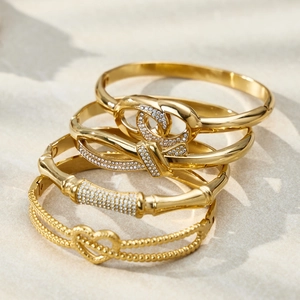 4-piece set of 18k gold plated stainless steel bangles with heart and crystal accents
