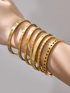 Macro shot of 7-piece gold-plated bracelet set with Roman numerals and heart details