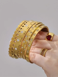 Detailed close-up of 18K gold plated hollow star bangles with zircon and Roman numerals