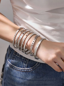 Macro detail of 18K gold plated stainless steel bangles with star and heart cutouts