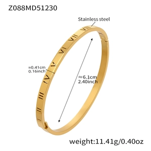 Macro detail of gold stainless steel bangle showing Roman numeral engravings and side clasp