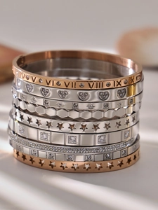 Detail showing Roman numeral engravings and zircon inlays on rose gold steel bracelets