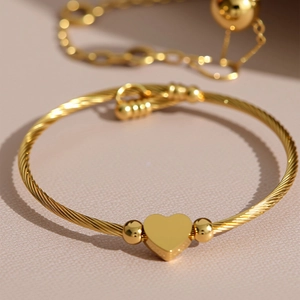 Golden heart charm bracelet with twisted metal wire band and polished round beads