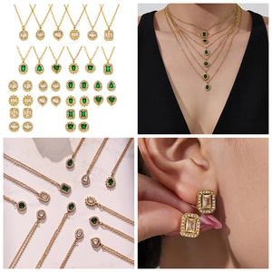 Detail view of vintage gold plated jewelry sets with emerald green and white zircons