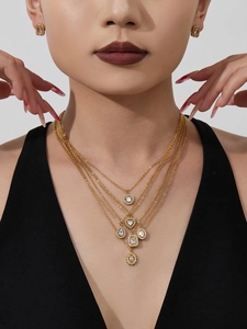 Detailed view of layered gold necklace and zircon earrings set worn on a model
