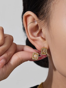 Detailed close-up of vintage gold earrings with champagne stone and zircon halo