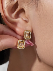 Close-up of gold-plated rectangular earrings with micro-pave cubic zirconia on earlobe