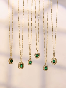 Detailed view of six gold-plated necklaces with emerald green stones and zircon accents