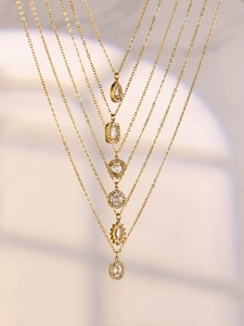 Detailed view of six gold-plated necklaces with various zircon inlaid crystal pendants