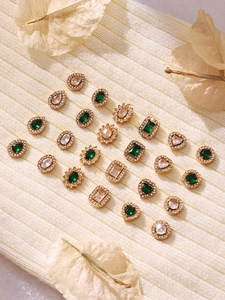 Detail of gold heart and teardrop studs with green zircon and micro-set diamonds
