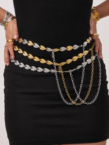 Detail of layered gold and silver leaf chain belt on a black dress with draped accents
