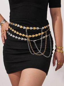 Detail of a layered gold and silver toned metal waist chain with textured oval plates