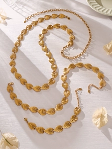 Detail of gold leaf-textured necklace links with embossed stripes and lobster clasp closure