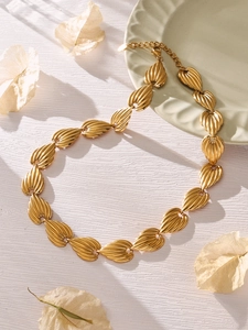Close-up of gold vintage leaf necklace with textured segments and adjustable lobster clasp