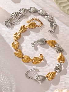 Detail view of mixed gold and silver stainless steel shell-texture chain link jewelry