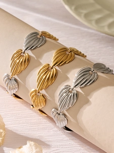 Macro detail of leaf-shaped metal links in gold and silver finish with fine textures