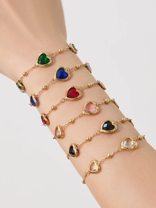 Détail de bracelets cœur avec pierres fines et perles dorées sur mannequin
