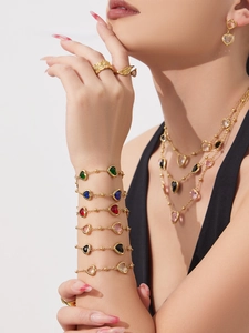 Détail de colliers superposés plaqués or 18k avec bracelets en pierres fines colorées