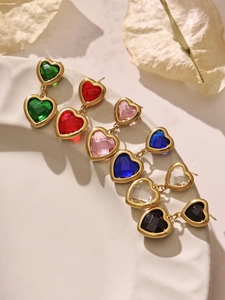 Détail de boucles d'oreilles de luxe en verre en forme de cœur en six couleurs sur un plateau