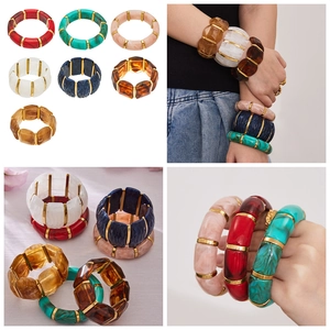 Dettaglio di bracciali bohémien larghi in resina marmorizzata con distanziatori dorati colorati