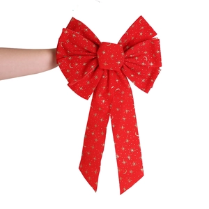 Large red velvet Christmas bow with gold glitter stars shown for size comparison