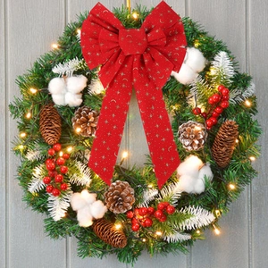 Detail of red Christmas bow with gold star and moon patterns on a festive wreath