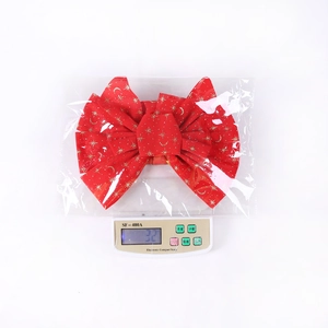 Detail of red velvet Christmas bow with gold star patterns on an electronic scale