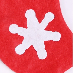 Close-up of red non-woven Christmas stocking featuring a white snowflake pattern texture