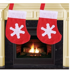 Close-up of red Christmas stockings with white snowflakes and plush trim decorations