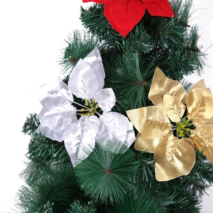Dettaglio di fiori natalizi artificiali rossi, oro e argento su rami di pino verdi