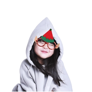 Détail de lunettes de Noël avec paillettes rouges, chapeau de lutin et oreilles sur une fille
