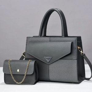 Detail of grey paneled tote set with striped fabric and gold chain mini bag accessory