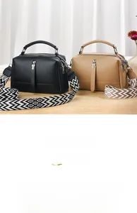 Detail of soft pebbled PU leather square bag with patterned wide strap and double zippers