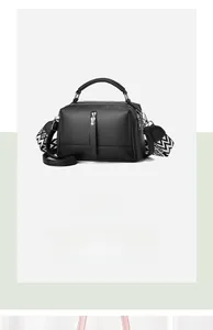 Detail of black pebbled leather crossbody bag with geometric pattern wide strap and silver hardware