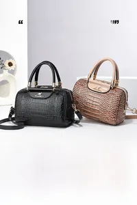Detail of black and brown crocodile pattern tote bags with kangaroo metal logo and straps